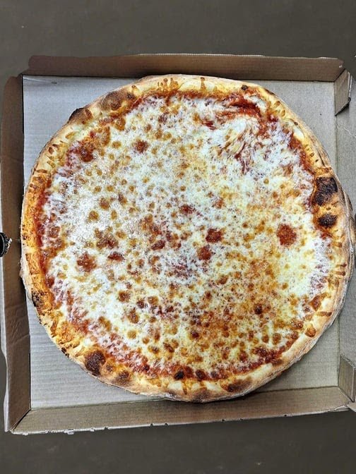 Printed menu beside a pizza restaurant setting.